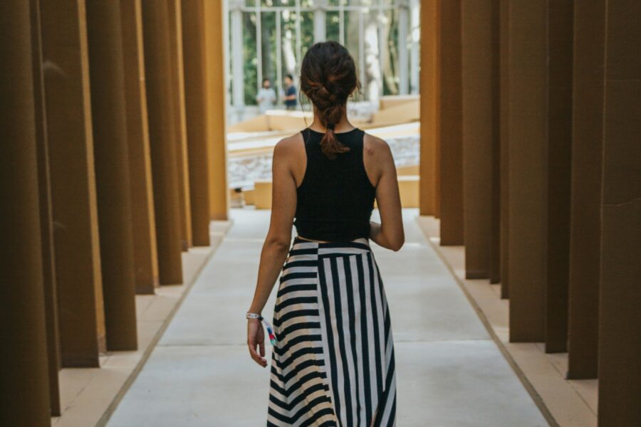 Brunette author walking along a corridoe of light